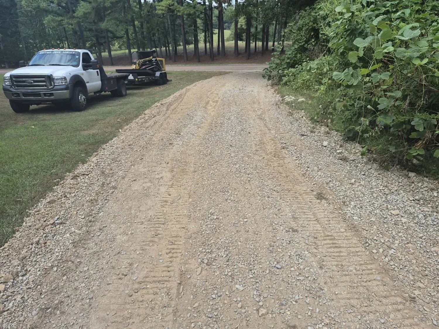 Same gravel driveway after land plane resurfacing, smooth and level from edge to edge using the existing gravel