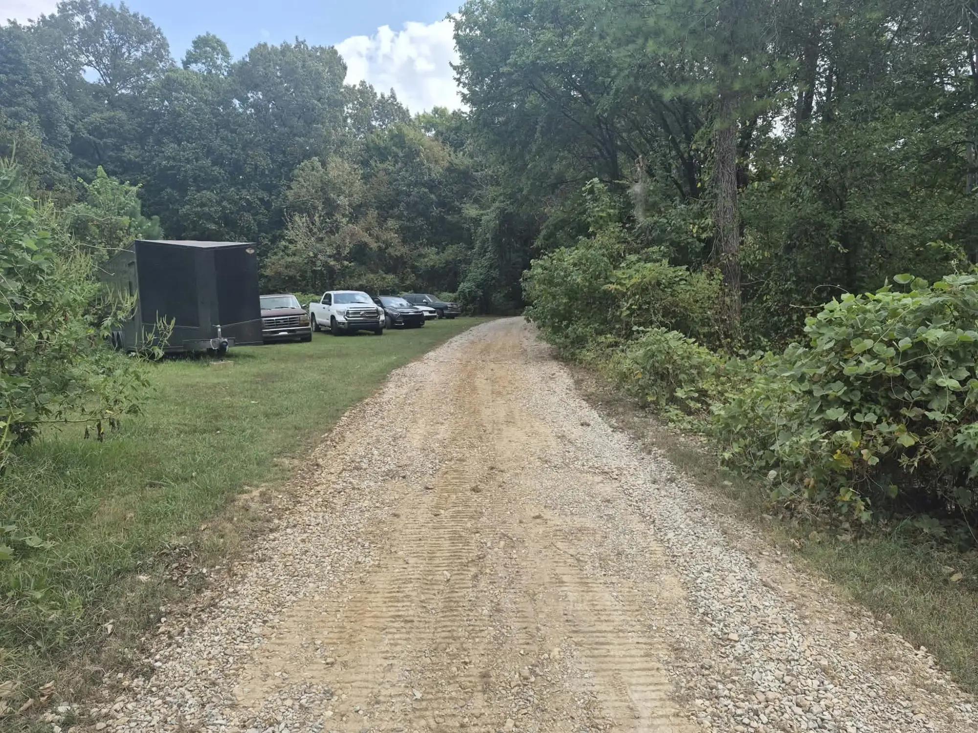 Resurfaced gravel driveway with a wide, even surface after land planing by Brush Brothers
